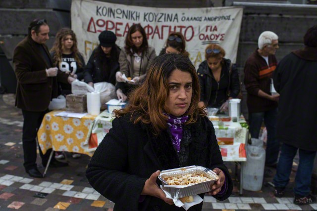 20 Jan 2015, Athens, Attica, Greece --- A woman receives a portion of food at a soup kitchen, organized during the years of the Greek economic crisis by 